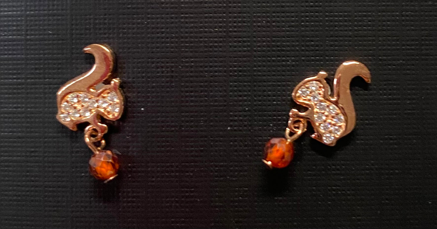 A pair of rhinestone stud earrings designed to look like squirrels with brown rhinestone acorns.