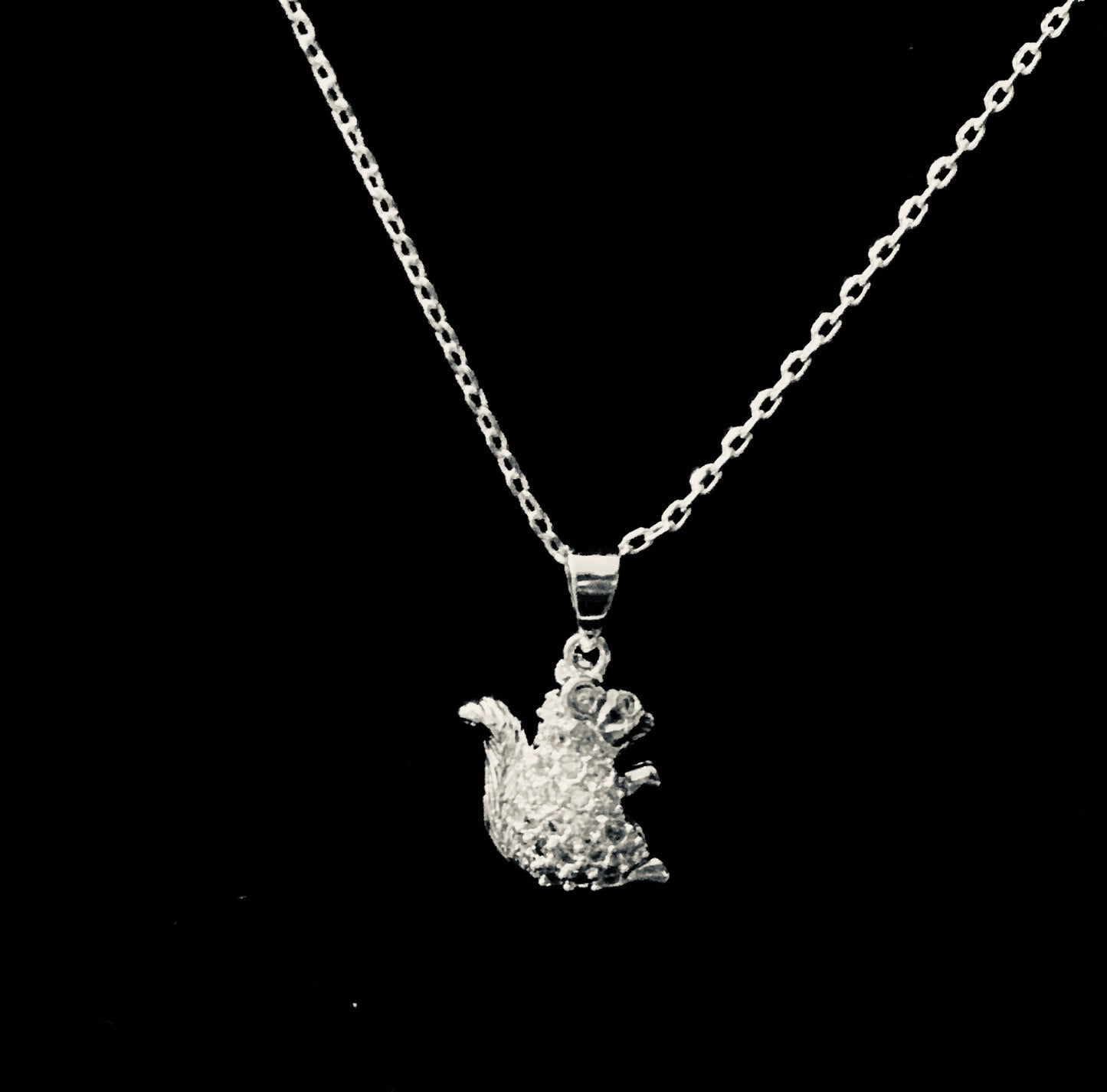 A sterling silver rhinestone squirrel pendant attached to an adjustable silver chain necklace.