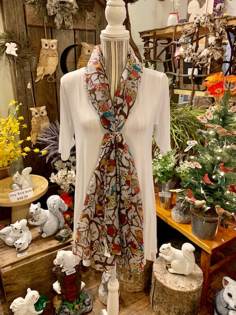 Scarf ring with crystals shown on a scarf and shirt on a display.