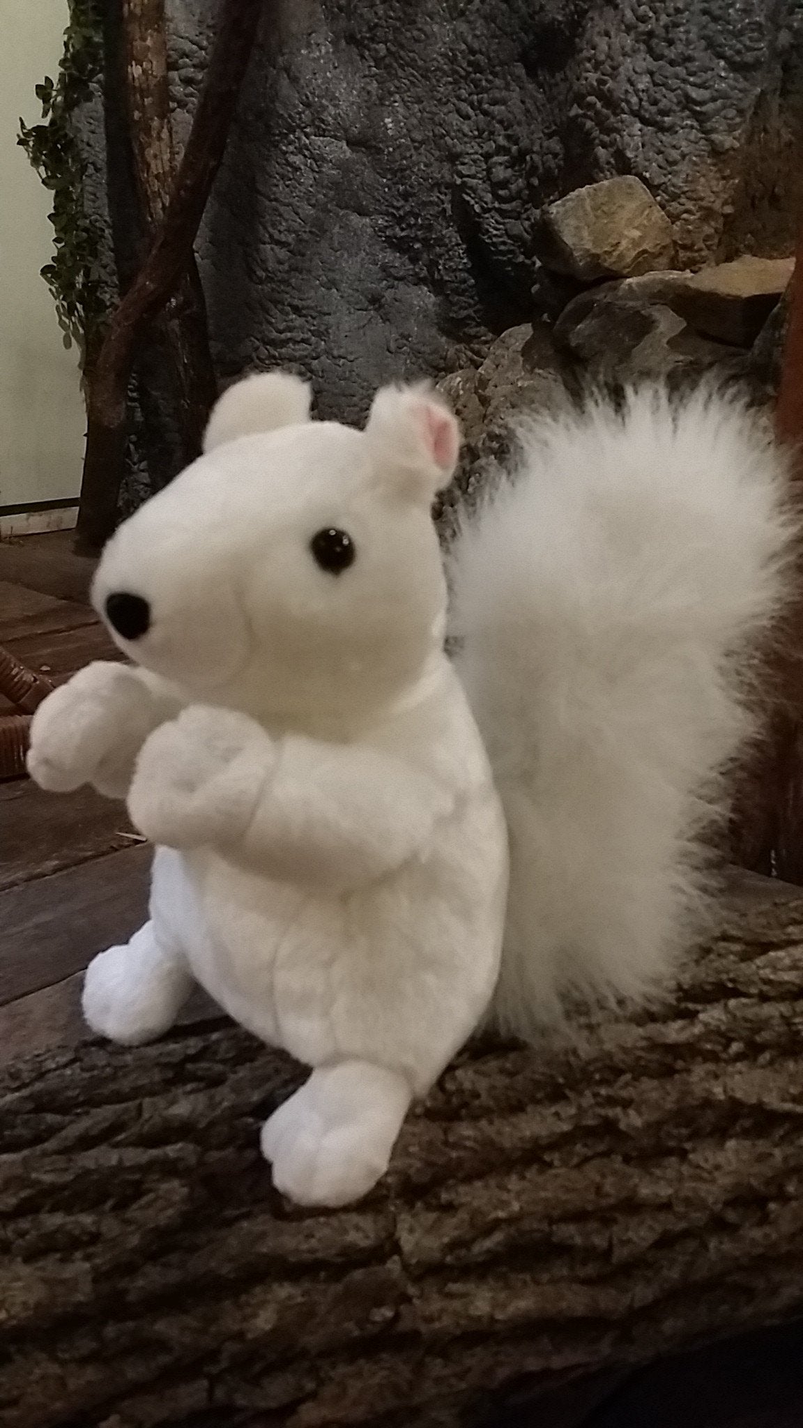 A large plush white squirrel with black nose and eyes, sitting upright.