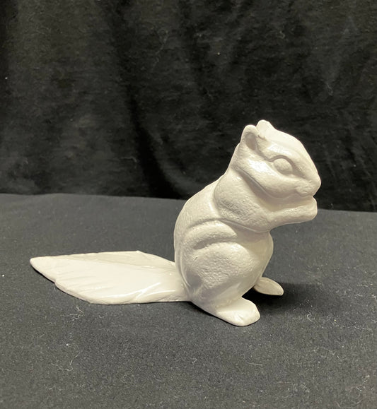 A small white squirrel door stop