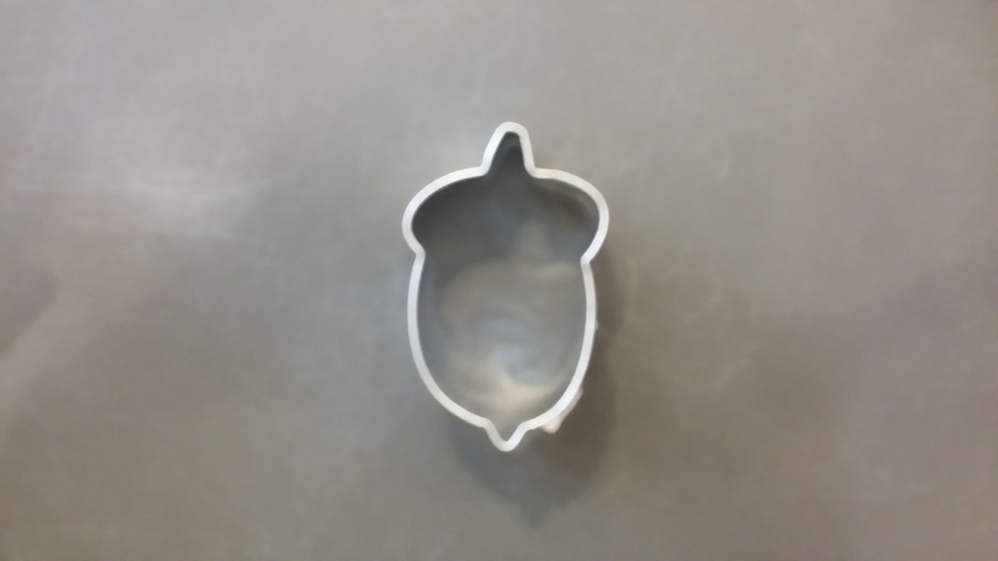 Metallic turtle-shaped cookie cutter on a reflective surface