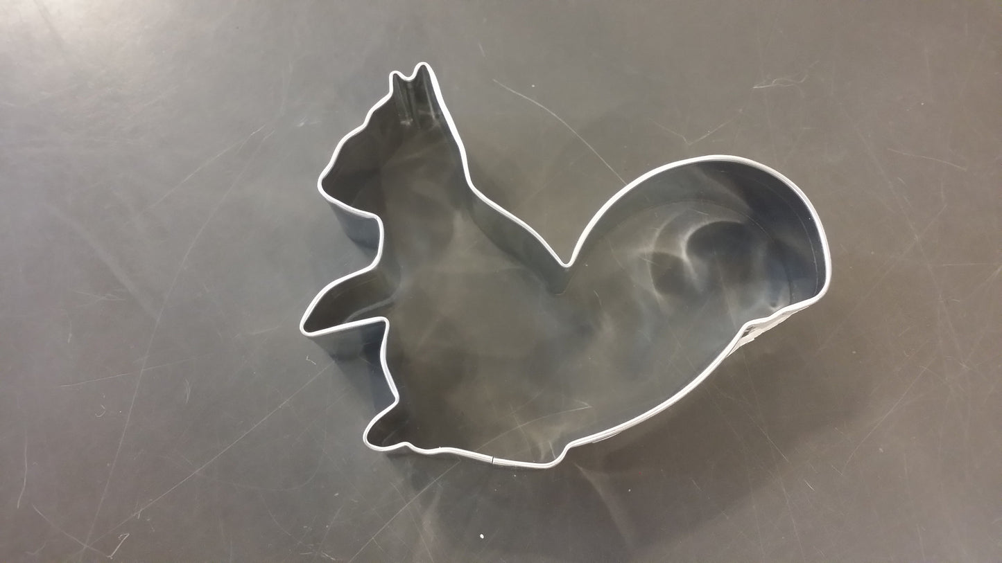 Metallic squirrel-shaped cookie cutter on a metallic surface