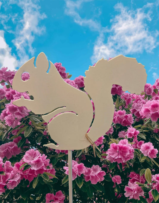 Metal Garden Stake in the shape of a white squirrel in a garden of pink azaelas