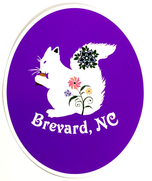 A round purple decal with the silhouette of a white squirrel holding a floral tail, and the text 'Brevard, NC' in the center.