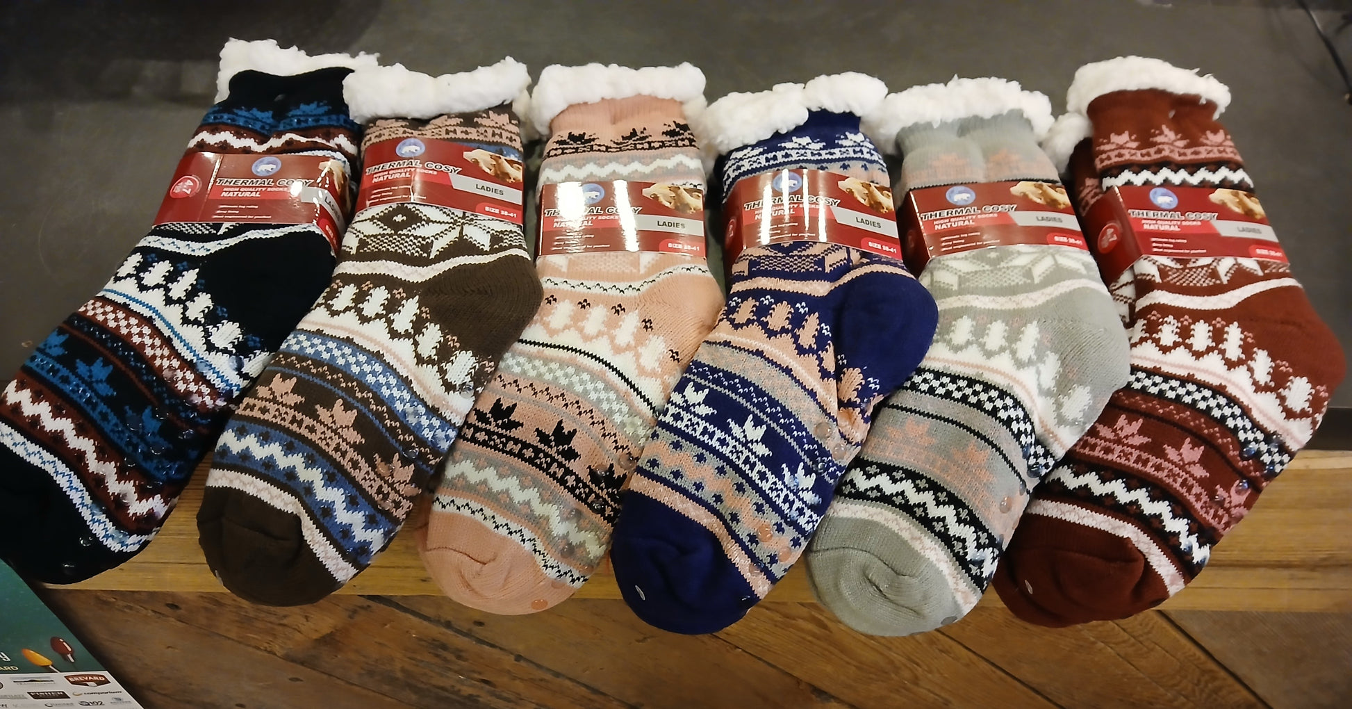 A collection of colorful fleece-lined slipper socks with no-slip bottoms displayed on a surface.