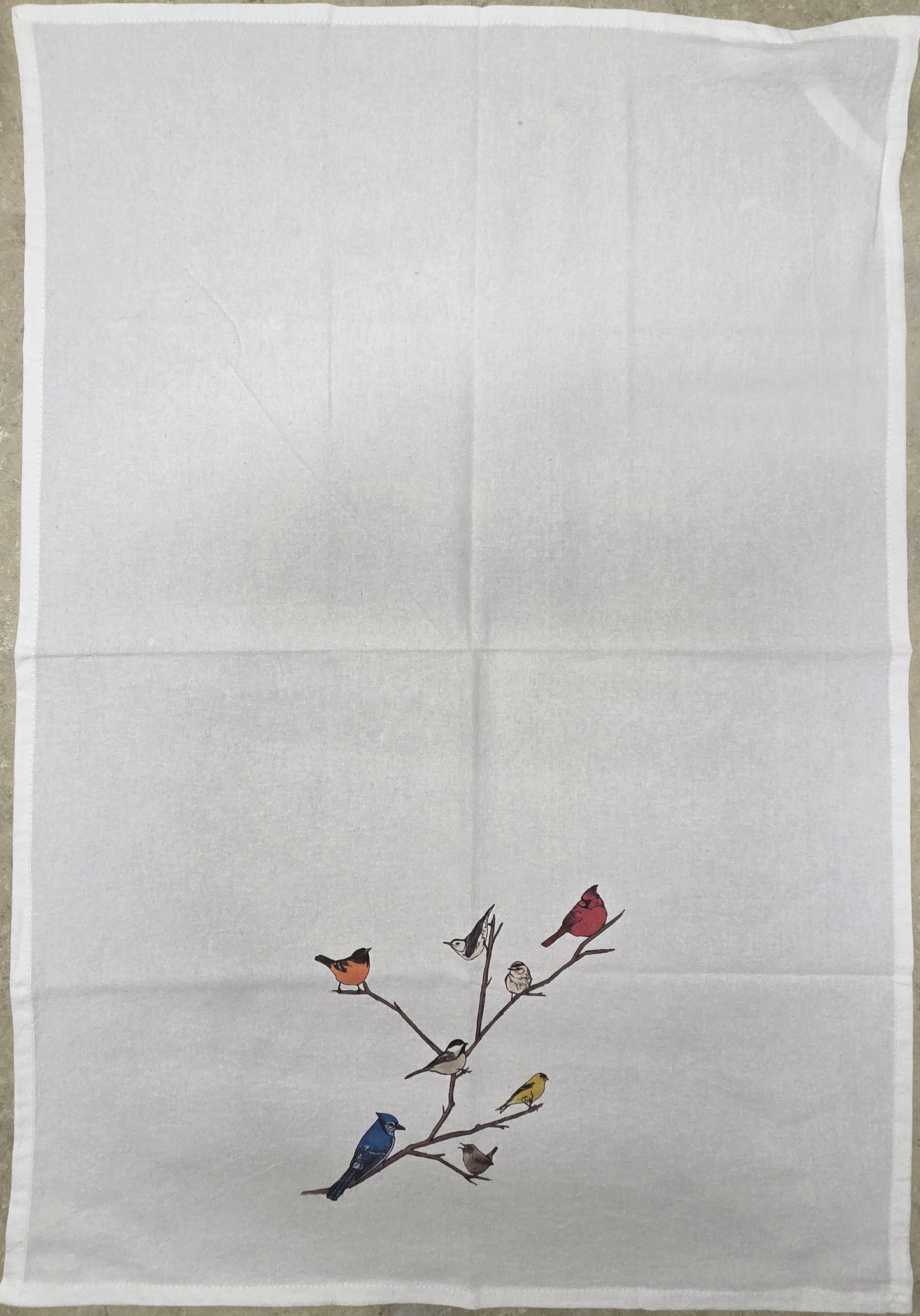 Embroidered design of birds on a branch on a white fabric background