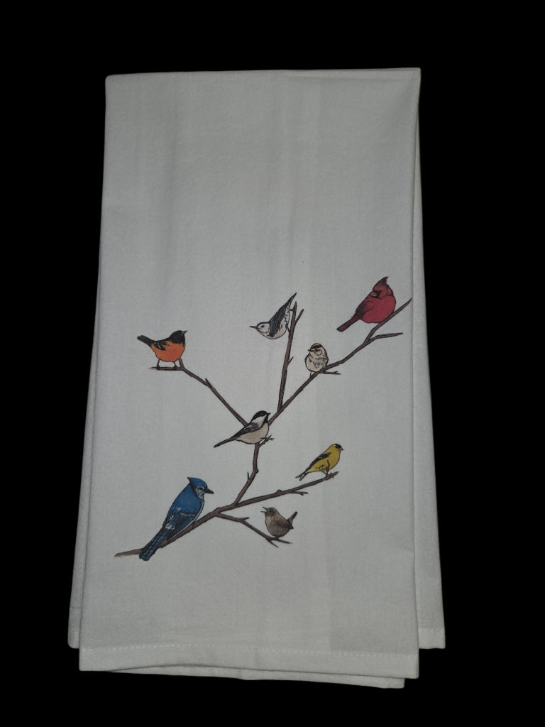 White towel with colorful bird illustrations on a branch against a black background