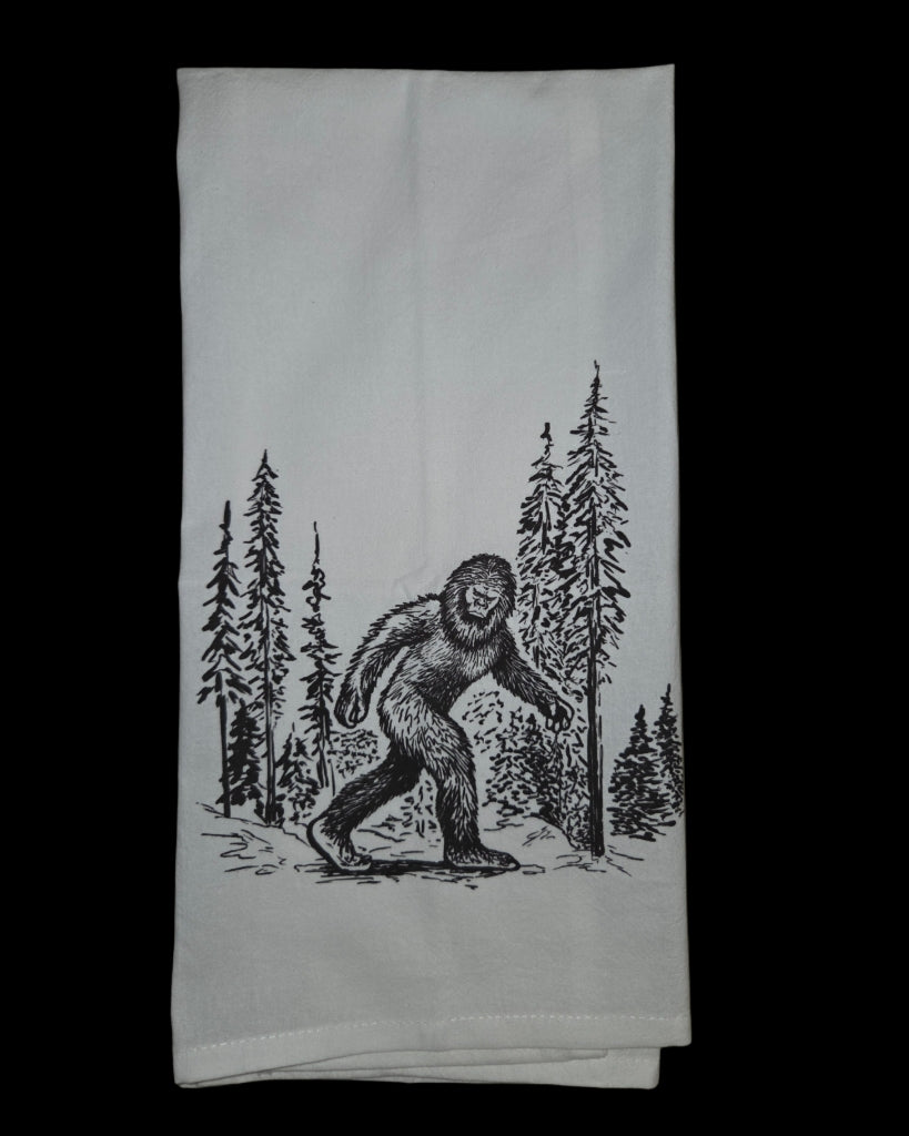 White towel with black graphic of a Sasquatch in a forest
