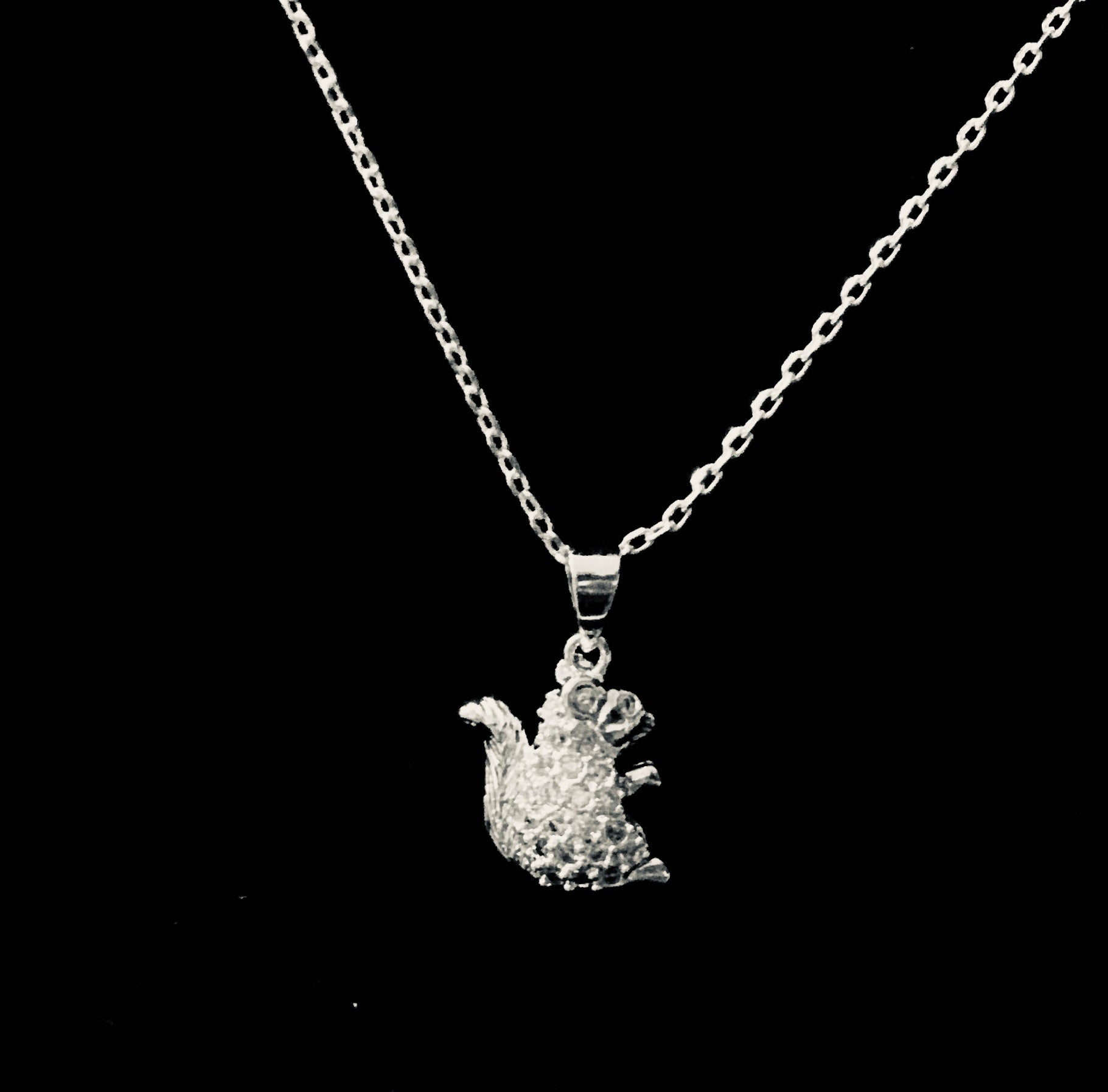 A sterling silver rhinestone squirrel pendant attached to an adjustable silver chain necklace.
