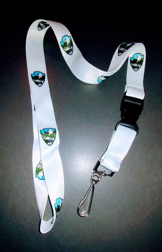 A white lanyard featuring a repeating image of a white squirrel on a bicycle with blue accents and text reading ' Assault on the Carolinas'.