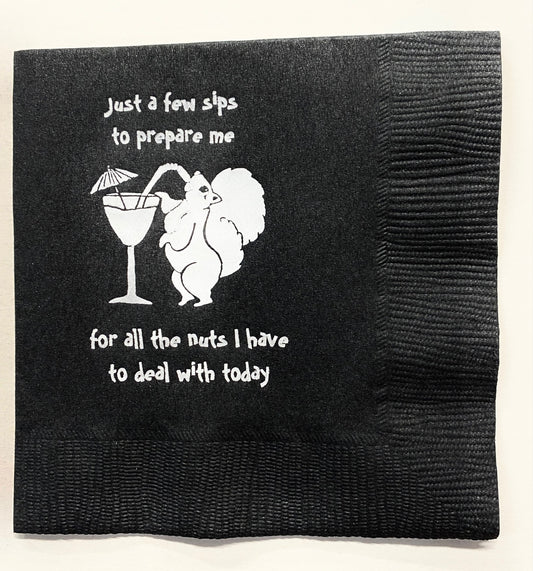 Black cocktail napkin with a white squirrel sipping a martini and saying, "Just a few sips to prepare me for all the nuts I have to deal with today.