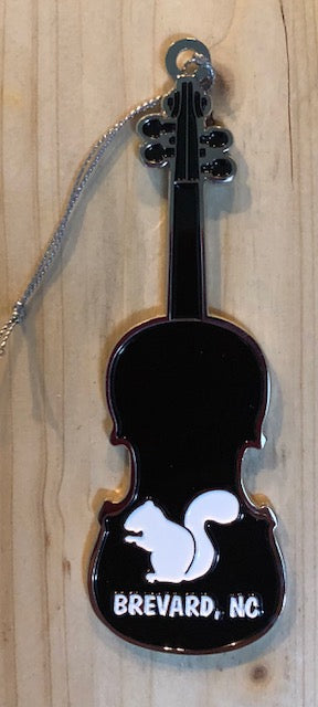 Metal ornament in the shape of a violin with white squirrel silhouette and 'Brevard, NC' on back. 