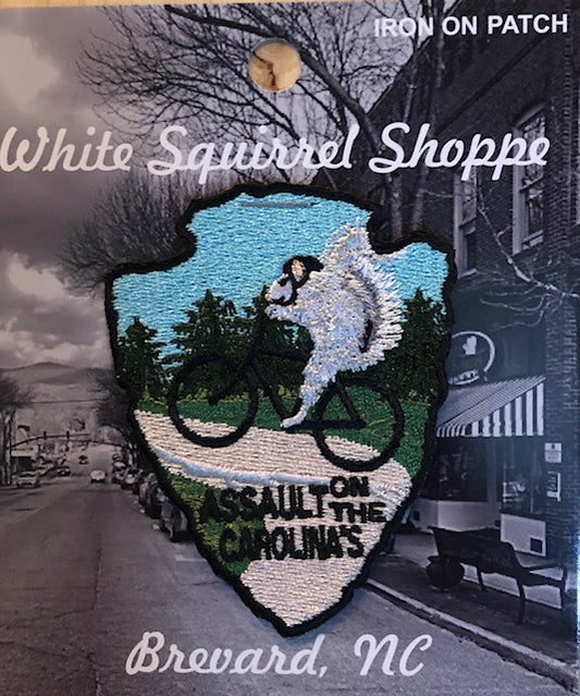 An embroidered iron-on patch featuring our white squirrel riding a mountain bike, with the text 'Assault on the Carolinas'.
