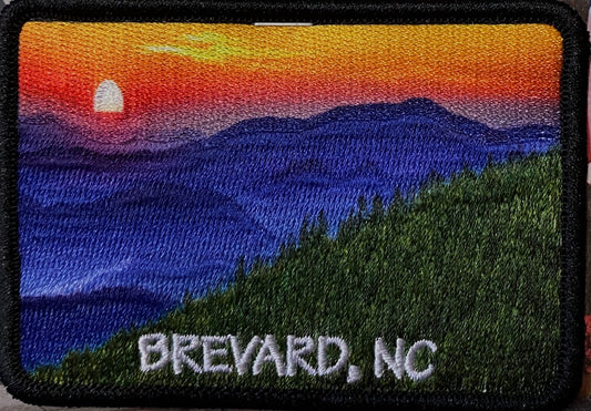 A patch with a photo-over mountain sunset scene, with the text 'BREVARD, NC' at the bottom.