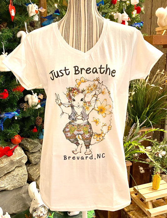 A white short sleeve fitted v-neck t-shirt for ladies with a graphic design of a hippie white squirrel girl and the text 'Just Breathe Brevard,NC'.
