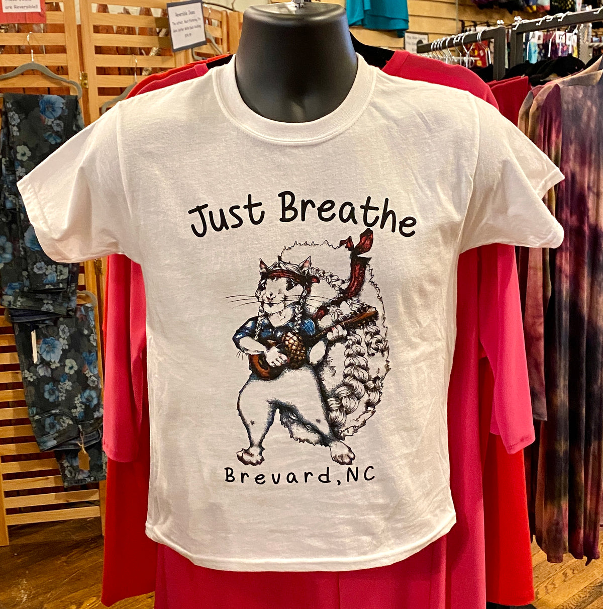 A white youth T shirt with a Willie Nelson white squirrel graphic with the words Just Breathe and Brevard, NC