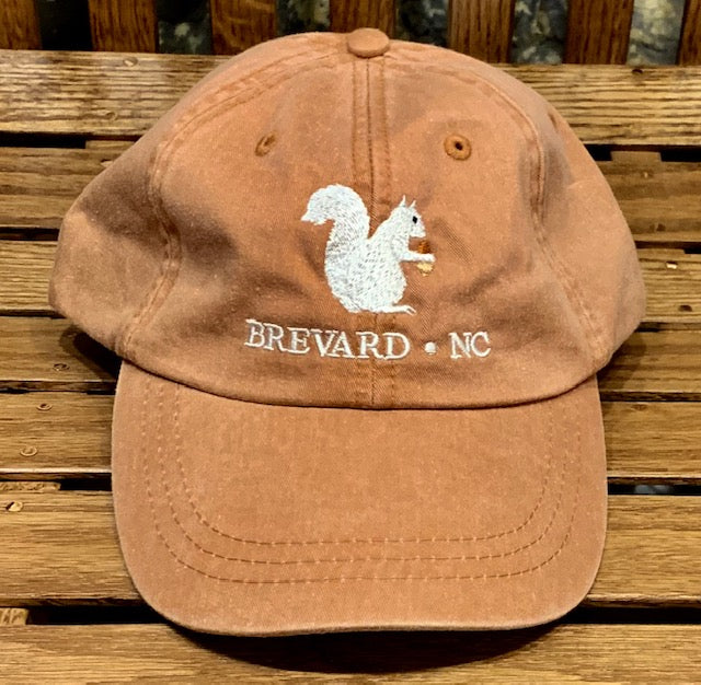 White Squirrel embroidered baseball cap from Brevard NC in terra cotta orange color